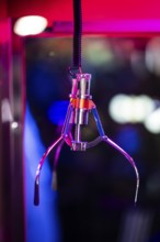 A shiny gripping arm of a vending machine, combination of vending machine and slot machine under