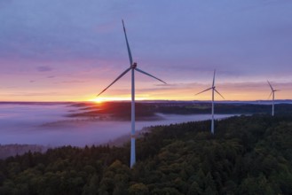 Wind turbines on a hill with sunlight breaking through the fog, sunrise, near Schorndorf, Remstal,