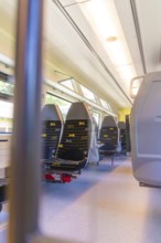 Bright train interior with several rows of seats, battery Electric train with green electricity,