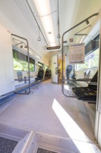 Large, bright interior of a train with wide windows, battery Electric train with green electricity,