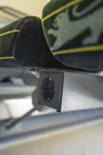 Close-up of a seat with integrated socket inside a vehicle, battery Electric train powered by green