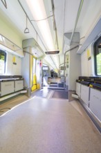 Interior of a modern vehicle with empty seats and large windows, battery Electric train powered by