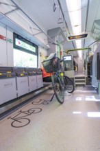 A modern designed train area for bicycles with seated cyclist, battery Electric train with green