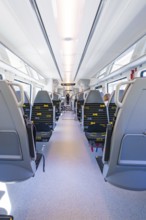 Interior view of a modern train with double-row seating arrangement, battery Electric train with