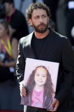 Venice, Italy - 3 September 2025: Motaz Malhees with a portrait of five-year-old Palestinian girl