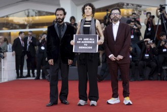 Venice, Italy - 1 September 2025: Charlie Kaufman, Eva H.D. and Josef Akiki with a sign reading -