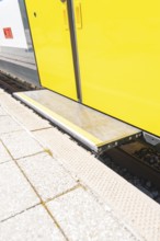 Close-up of a step on the yellow train belt line on the platform, battery Electric train with green