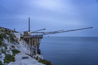 Historic pile dwelling of the fishermen Trabucco on the coast of Vieste at dusk, Gargano, Apulia,