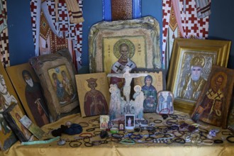 Table full of orthodox icons of various saints in an interior, Agios Nikolaos Chapel, harbour,
