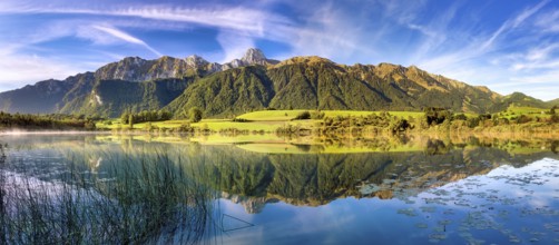 Stockhorn range with the Stockhorn mountain reflected in the Uebeschi lake in the morning light,