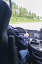 A driver sits in a vehicle on the motorway, view of the dashboard, Lake Constance, Germany