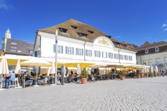Historic building with a café and yellow parasols in the sunshine, Lake Constance, Germany