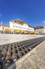 Café with yellow parasols and historic buildings under a clear sky, Lake Constance, Germany