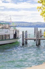 Boat at the pier on a lake under a cloudy sky, Lake Constance, Germany