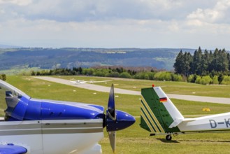 In the background runway and landing strip on it tow launching motorised aircraft towing glider