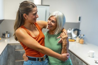 Senior mother and adult daughter hugging, sharing a tender moment of affection and familial bonding