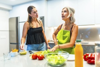 Two women engaging in meal preparation in a modern kitchen, focusing on fresh vegetables and