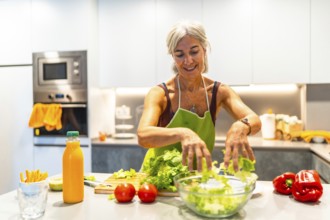 Elderly woman wearing an apron, making a salad with fresh ingredients in a bright kitchen,