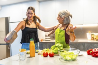Joyful grandmother and granddaughter preparing a healthy meal in a bright, modern kitchen,