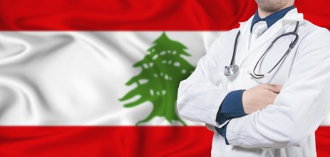 Lebanon healthcare concept. Male doctor on Lebanon flag. Doctor with crossed arms on Lebanon flag
