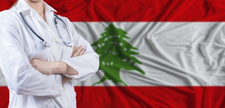 Doctor with crossed arms on Lebanon flag. Lebanese health and care concept. Female doctor on