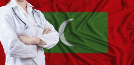 Doctor with crossed arms on Maldives flag. Maldivian health and care concept. Female doctor on