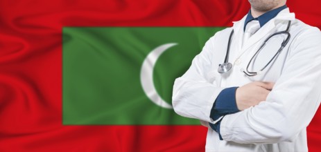 Maldives healthcare concept. Male doctor on Maldives flag. Doctor with crossed arms on Maldives