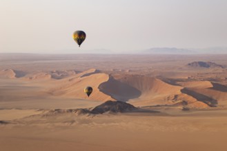 Two hot-air balloons at the edge of the Namib Desert. Aerial view from another balloon. Namibia