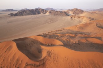 Sand dunes and mountain ridges in the Namib Desert. In the evening. Aerial view. Namib-Naukluft