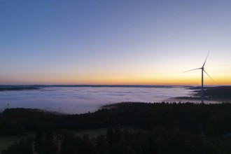 Single wind turbine with fog at sunrise along the horizon, near Schorndorf, Remstal,