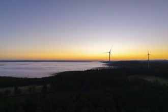 Darker morning sky with wind turbines and fog in the foreground, near Schorndorf, Remstal,