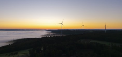 Several wind turbines above a foggy landscape at sunrise, near Schorndorf, Rems-Murr district,