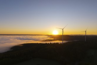 Wind turbines over foggy fields and hills at sunrise, near Schorndorf, Rems-Murr-Kreis,