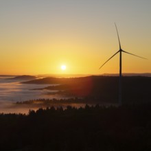 Wind turbine above a misty forest landscape at sunrise, near Schorndorf, Rems-Murr district,