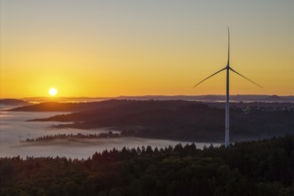 Wind turbine at sunrise over a misty hilly landscape, near Schorndorf, Rems-Murr district,