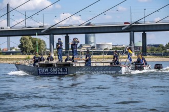Exercise trip of a multi-purpose pontoon on the Rhine, the skipper gives instructions to the two