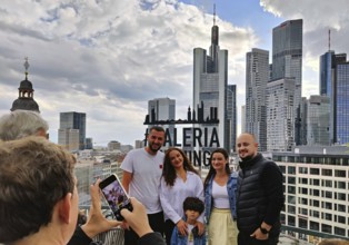 Souvenir photo at the sign of the Gallaria Skylounge with the banking district in the background on