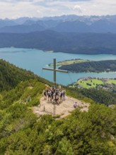 Group around a cross on a mountain peak with a panoramic view of the surrounding lakes, Herzogstand