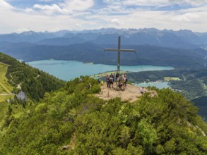 People on the summit with a cross, in the background a wide panoramic view, Herzogstand summit,