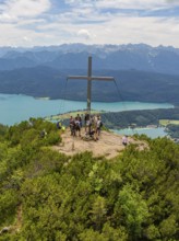 People standing around a summit cross with a view of the surrounding landscape, Herzogstand summit,
