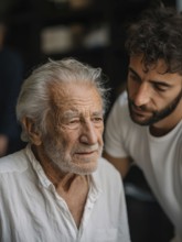 A young carer lovingly looks after a senior in an old people's home, nursing home, symbolic image
