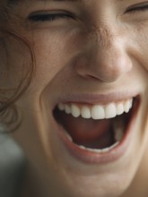 Laughing person with closed eyes and visible teeth, expression of pure joy, AI generated