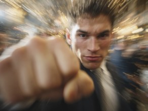 A man shows an outstretched fist to the camera while the background blurs into motion, symbolic