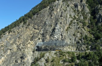 Yellow Swiss Post bus travelling under the safety nets against falling rocks to the Petits Pontis