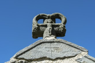 Stone cross on the bridge over the Pavin couze river flowing through the village of Saurier, Puy de