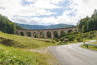 Adlitzgraben Viaduct, cloudy sky and green hills, Semmering Railway, Semmering, Lower Austria,
