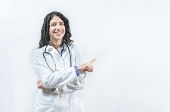 Female latin doctor pointing aside isolated. Smiling young female doctor pointing at side isolated