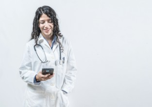 Smiling female doctor using smart phone isolated. Doctor holding phone, Concept of online medical