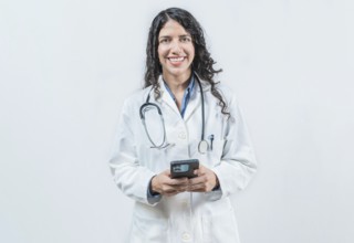 Young doctor holding phone, Concept of online medical services. Smiling female doctor using smart