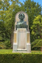 Bust of Joseph II on a monument, embedded in lush greenery and trees, spa garden Baden, Lower
